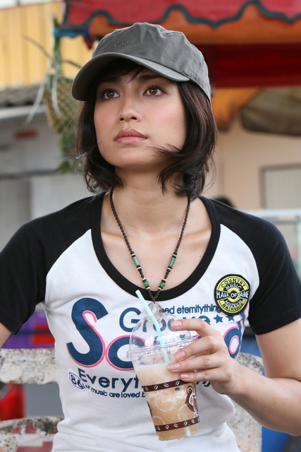 Tシャツにキャップをかぶっているコーヒーを持った佐田真由美の画像